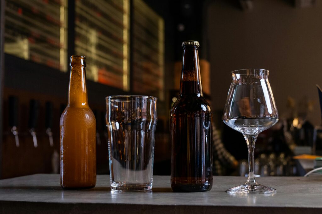 Beer bottles and glasses showcasing malt extract enzymes in brewing for flavor and clarity