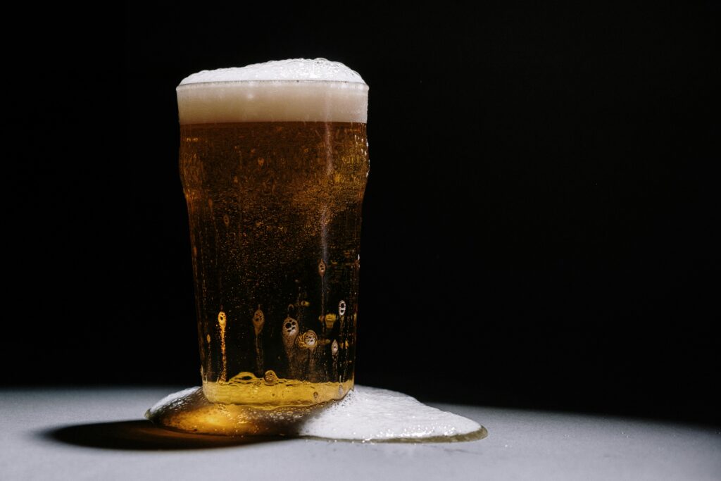 Glass of freshly brewed beer with foam, showcasing quality brewing using enzymes for better clarity and taste
